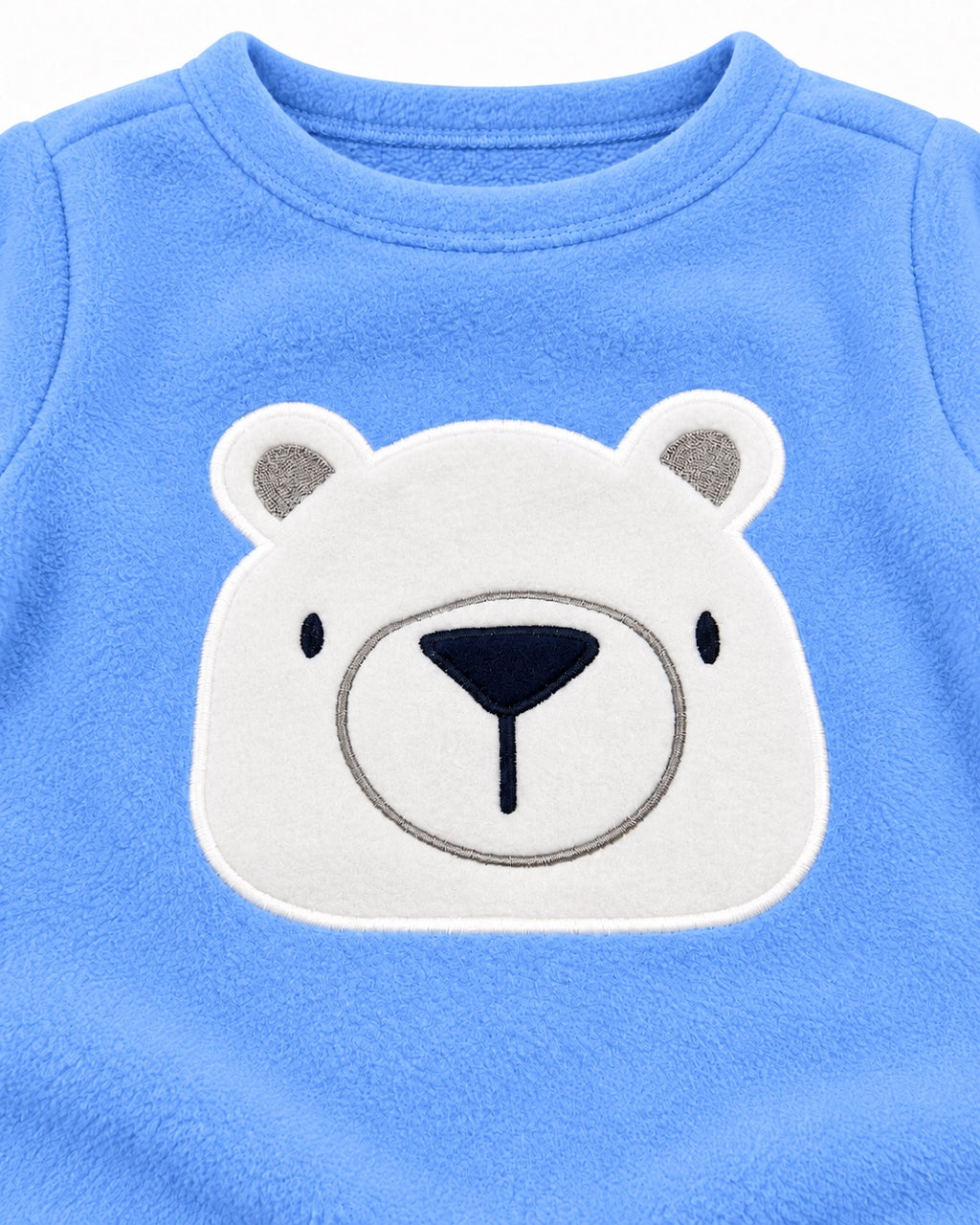 Close-up of white polar bear appliqué on blue fleece top