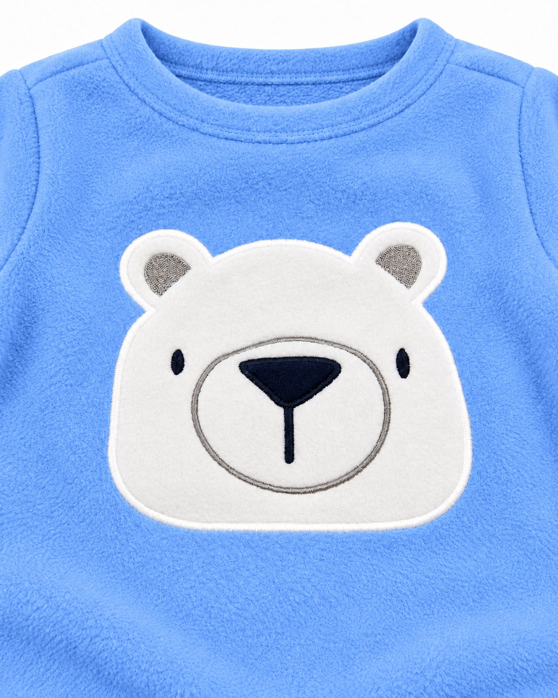 Close-up of white polar bear appliqué on blue fleece top