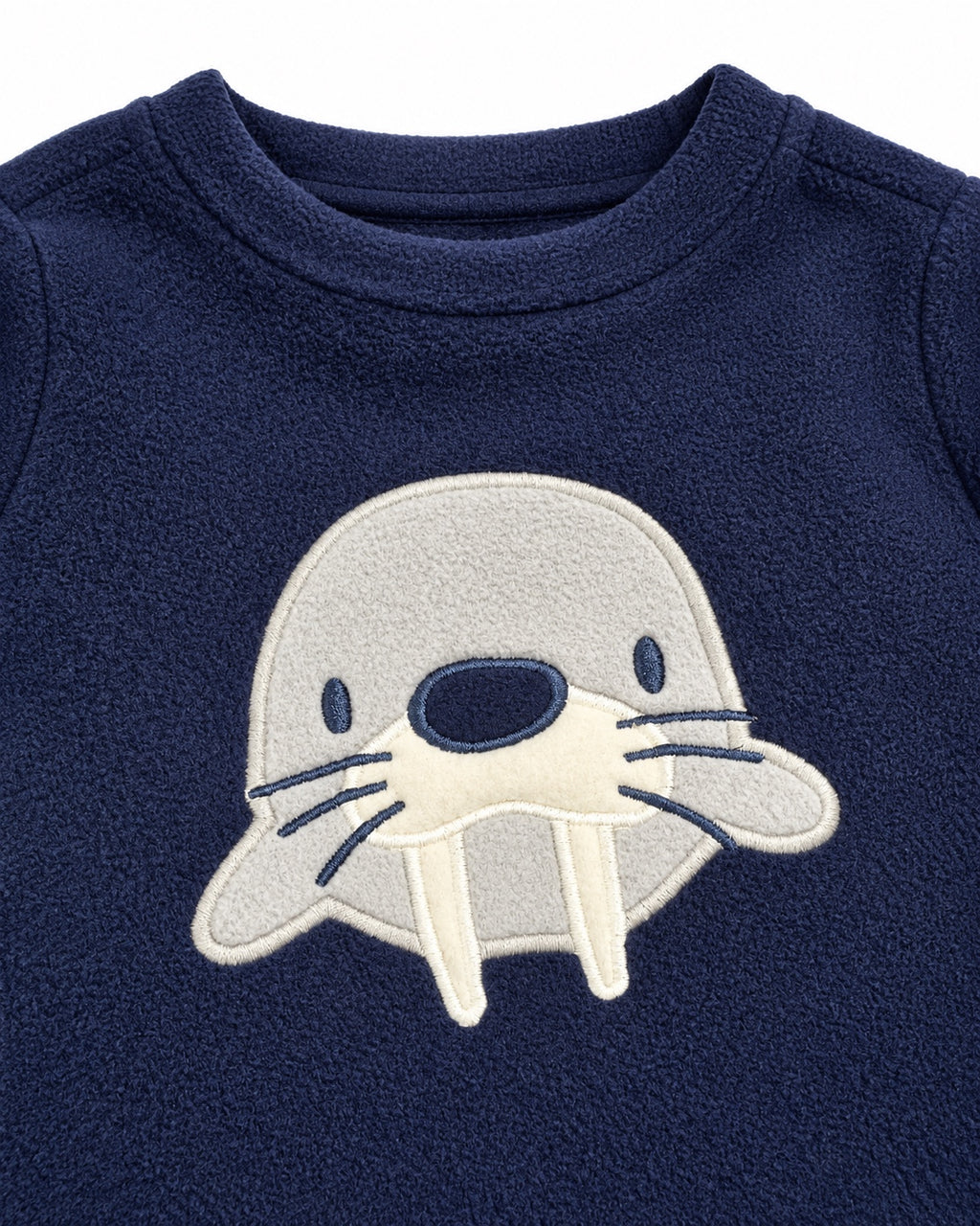 Close-up of walrus appliqué on navy fleece top