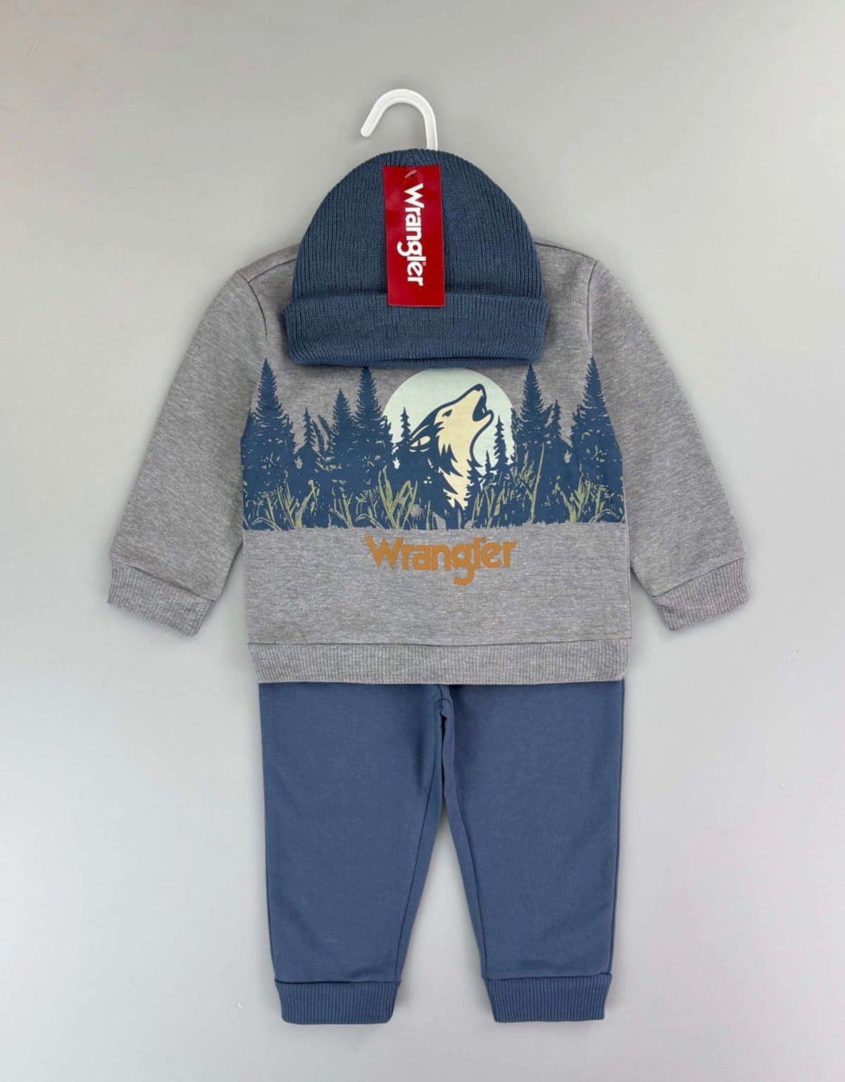 Wolf on Mountain print: grey Wrangler sweatshirt and blue trousers; beanie photographed